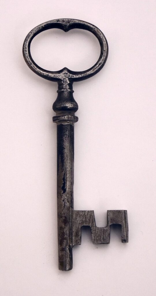 A large key is hanging on the wall.