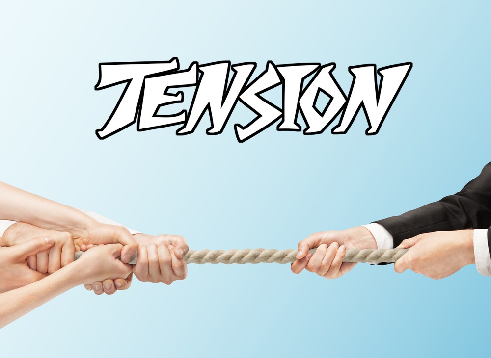 Two people are pulling a rope with the word tension on it.