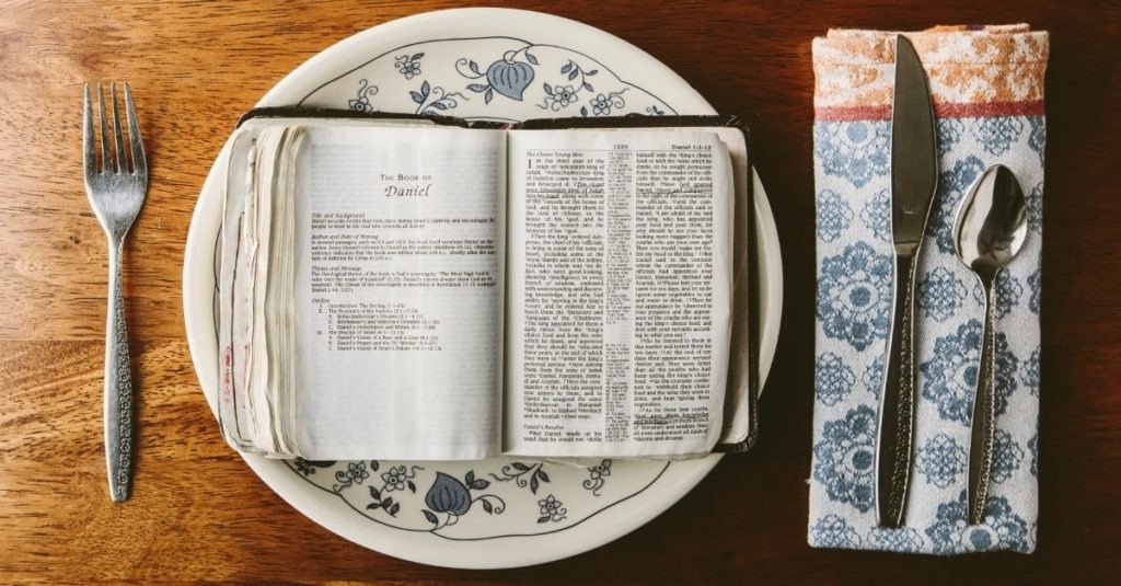 A bible open on top of a plate.