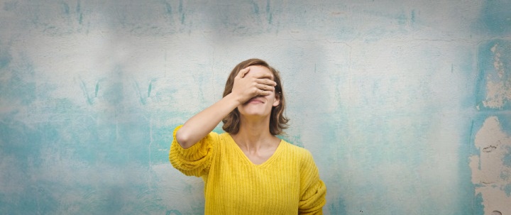 A woman covering her eyes with one hand.